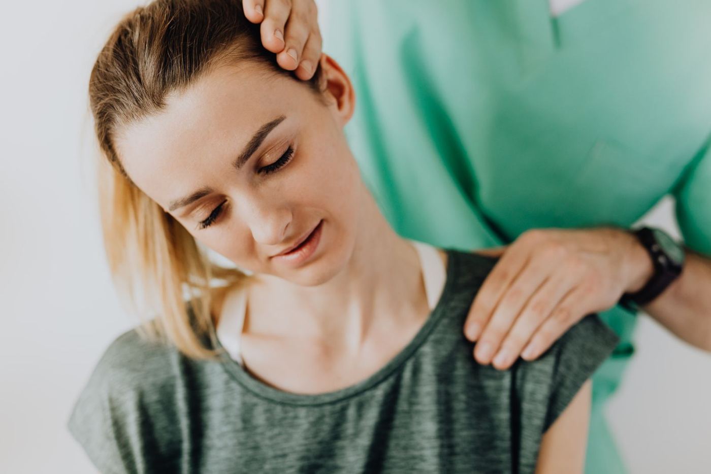 Clinician examining a patient's neck for soft tissue injury